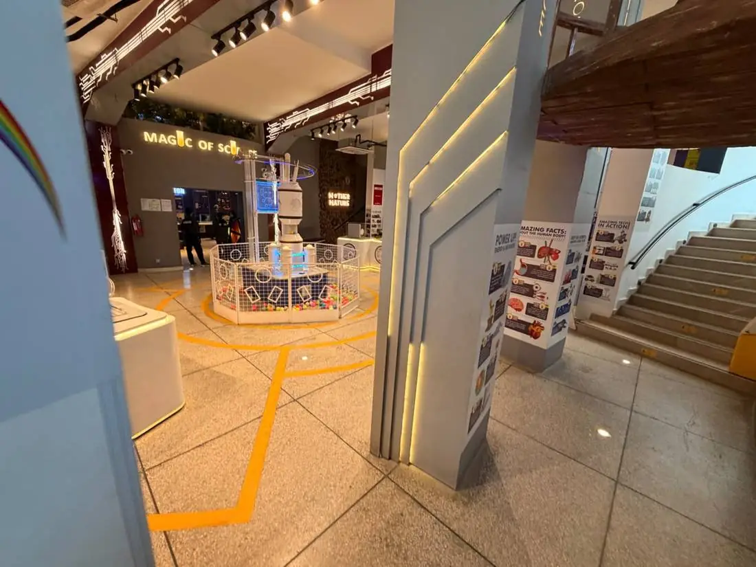 The Central Foyer of Joy of Science Lahore with zone signage and lit pillars